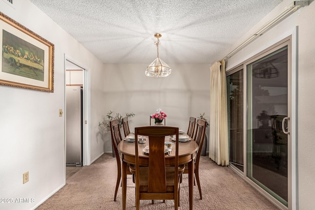 dining room featuring light carpet, baseboards, a chandelier, and a textured ceiling