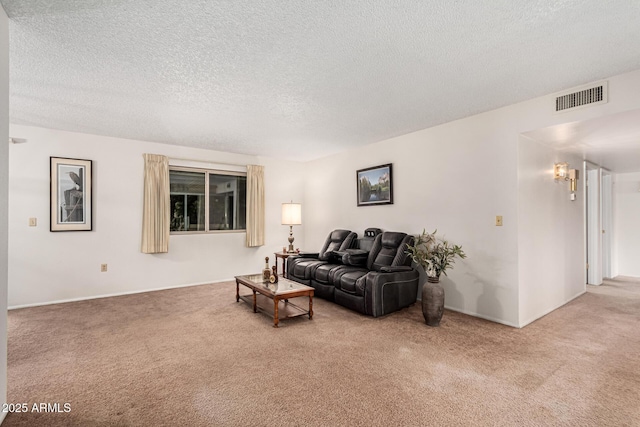 carpeted living room featuring visible vents and a textured ceiling