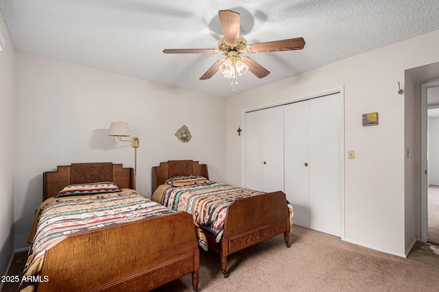 bedroom with carpet floors, a closet, a textured ceiling, and a ceiling fan