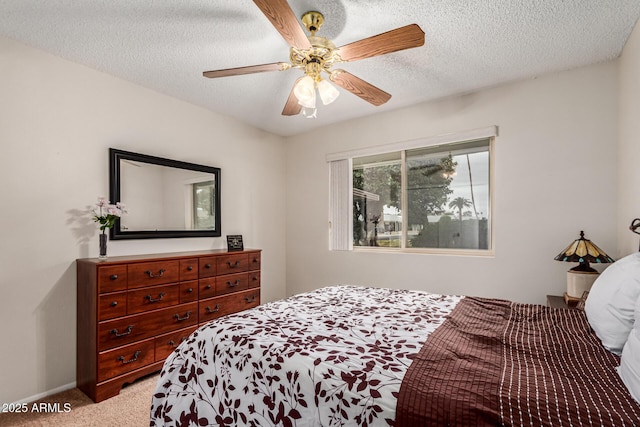 carpeted bedroom with a textured ceiling, ceiling fan, and baseboards