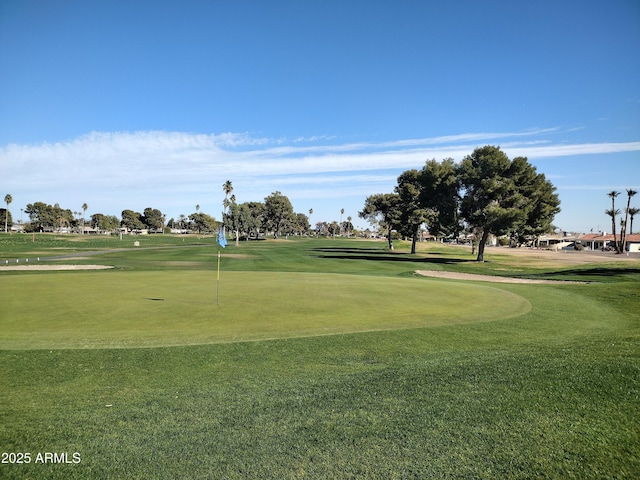 view of community with view of golf course and a yard