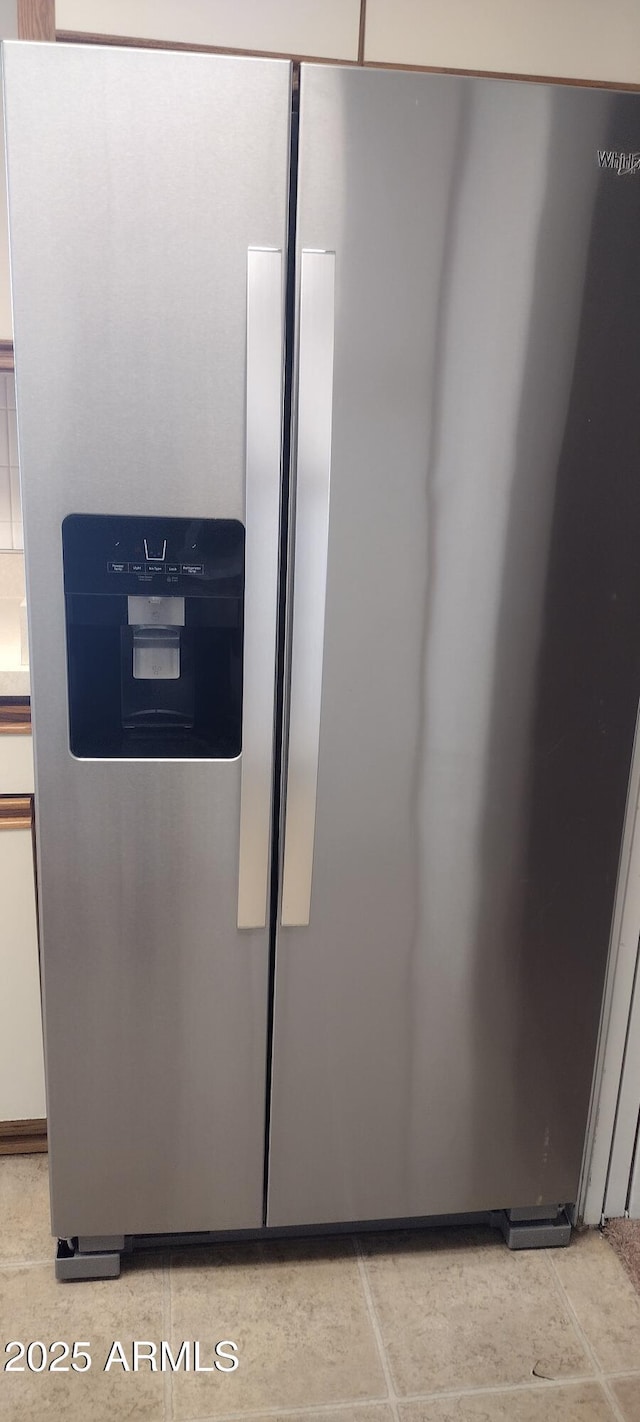 interior details featuring stainless steel refrigerator with ice dispenser