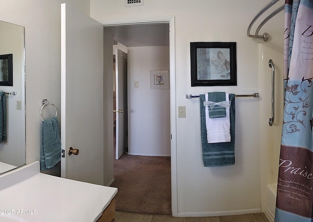 full bath featuring visible vents, vanity, and baseboards