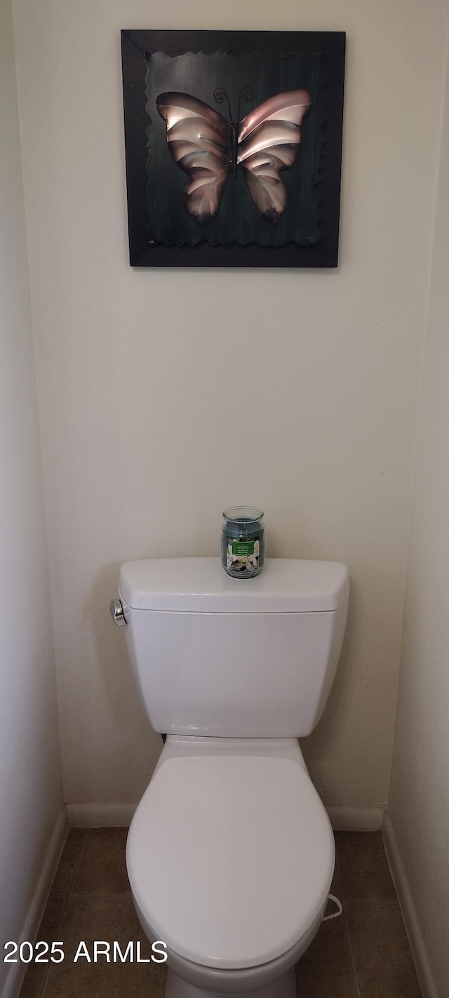 bathroom with toilet, baseboards, and tile patterned floors