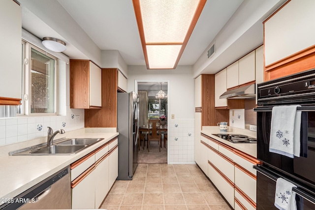 kitchen featuring light countertops, visible vents, a sink, under cabinet range hood, and black appliances