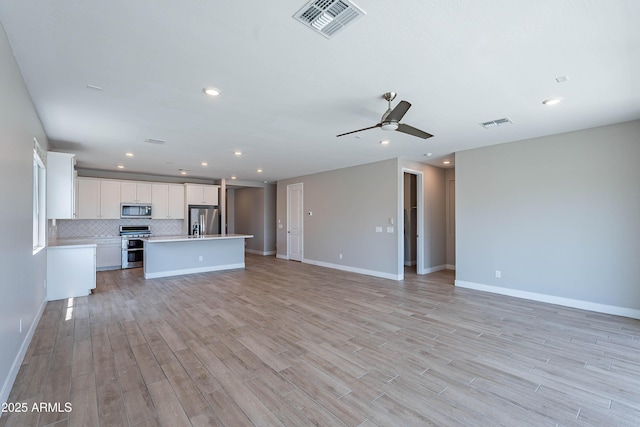 unfurnished living room featuring ceiling fan, light wood-type flooring, recessed lighting, and baseboards
