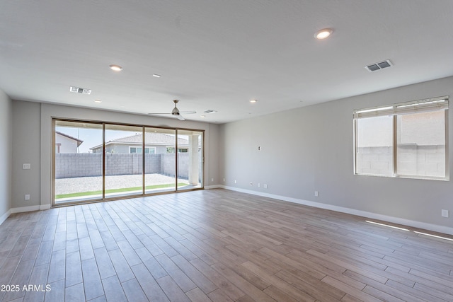 empty room featuring ceiling fan, baseboards, wood finished floors, and recessed lighting