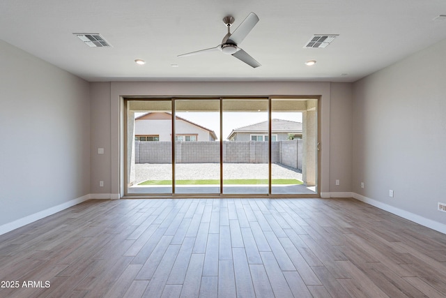 empty room featuring wood finished floors, ceiling fan, and baseboards
