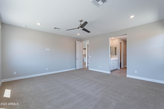 unfurnished bedroom with light carpet, baseboards, ensuite bath, recessed lighting, and a ceiling fan