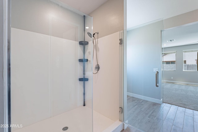bathroom featuring a stall shower, wood finished floors, and baseboards