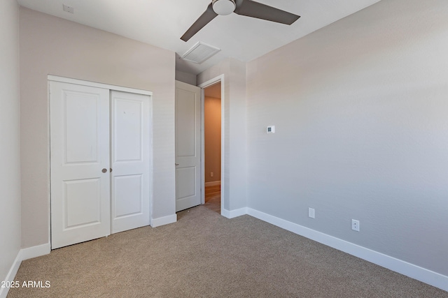 unfurnished bedroom with carpet flooring, a closet, baseboards, and a ceiling fan