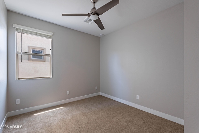 spare room with carpet floors, ceiling fan, and baseboards