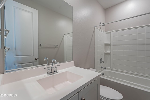 bathroom featuring toilet, shower / bath combination, vanity, and a textured wall