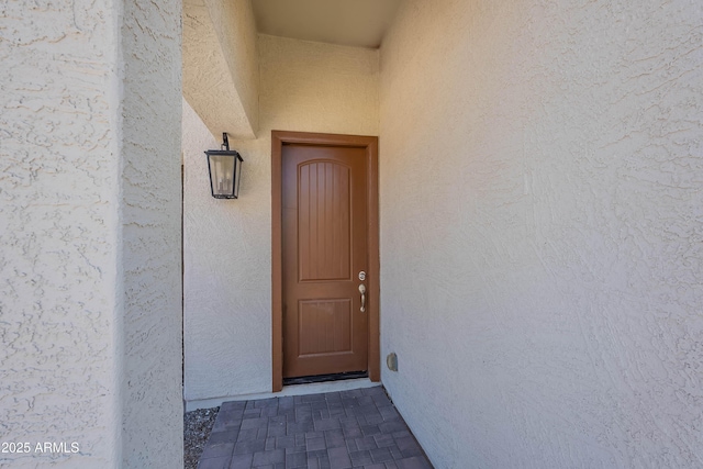 entrance to property with stucco siding