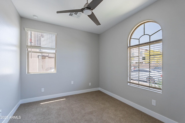 empty room featuring a ceiling fan, carpet, and baseboards