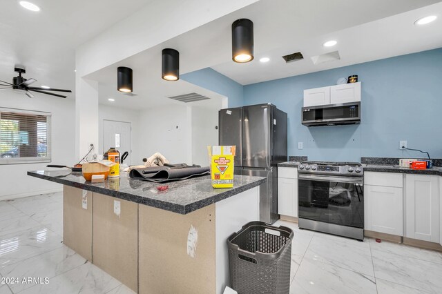 kitchen featuring light tile patterned flooring, white cabinetry, a kitchen island, ceiling fan, and stainless steel appliances