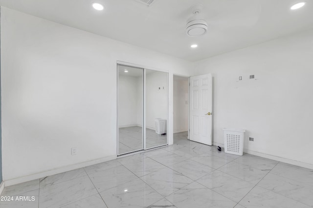 unfurnished bedroom with light tile patterned flooring, ceiling fan, and a closet