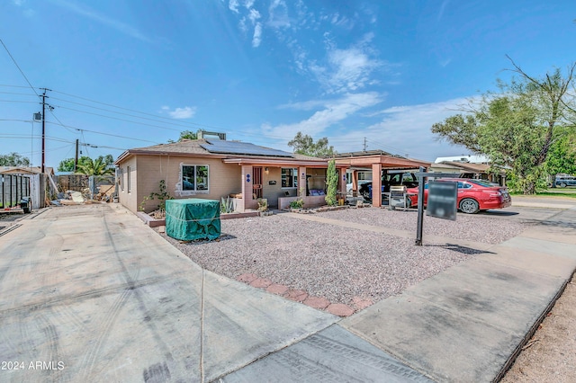 ranch-style home with a porch and solar panels