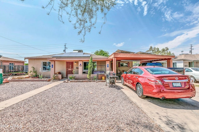 ranch-style house with solar panels and a porch