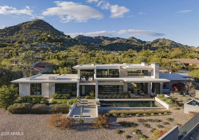 rear view of property featuring a mountain view and a patio area