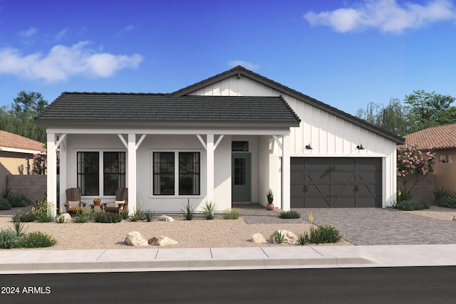 modern inspired farmhouse featuring covered porch and a garage