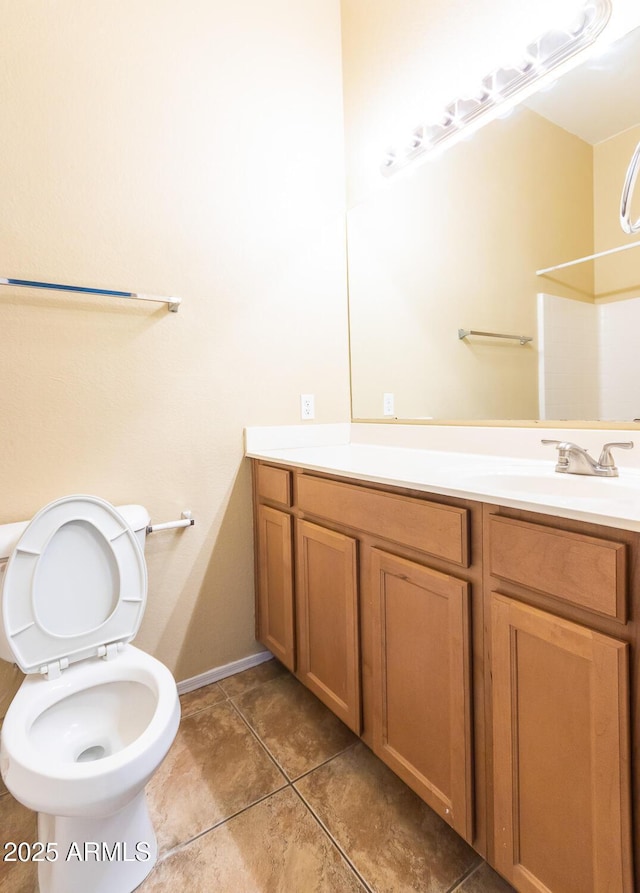 bathroom featuring toilet, vanity, and tile patterned flooring