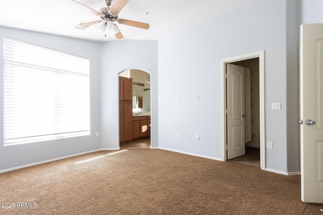 unfurnished bedroom featuring ceiling fan, carpet, and ensuite bath