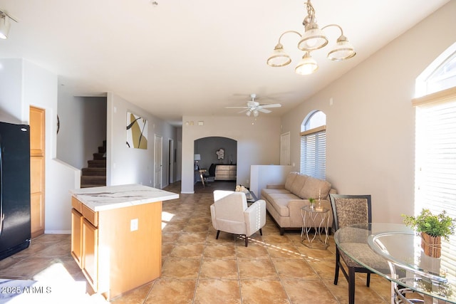 living room featuring ceiling fan with notable chandelier and light tile patterned floors