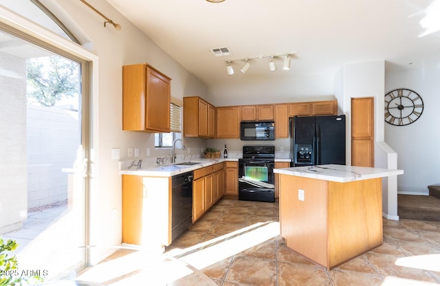 kitchen featuring sink, black appliances, a center island, and light tile patterned flooring