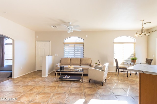 living room featuring ceiling fan with notable chandelier and light tile patterned floors