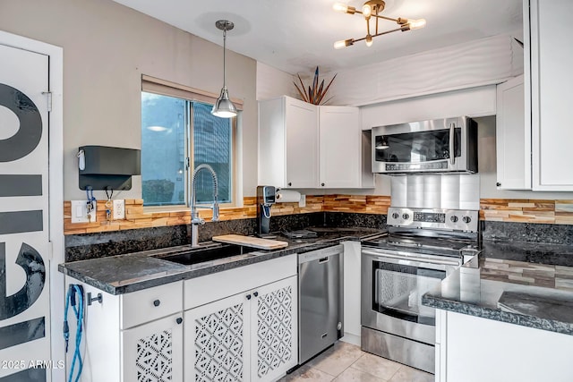 kitchen featuring stainless steel appliances, white cabinetry, a sink, and tasteful backsplash