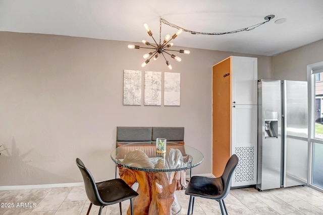 dining room with baseboards and an inviting chandelier