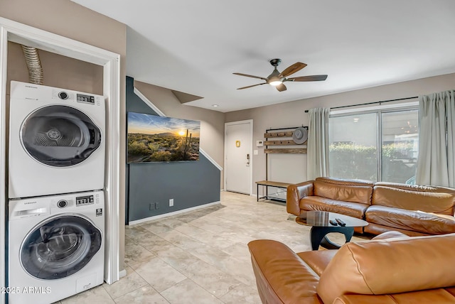 laundry room with a ceiling fan, stacked washer and clothes dryer, and laundry area