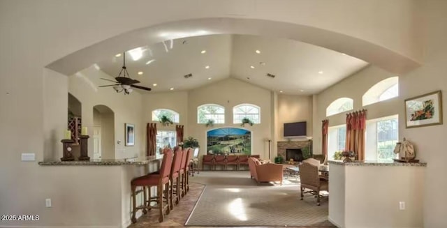 5335 E Shea Blvd Unit 2081, Scottsdale, AZ 85254 - living area featuring a towering ceiling, healthy amount of natural light, a ceiling fan, a fireplace, and arched walkways
