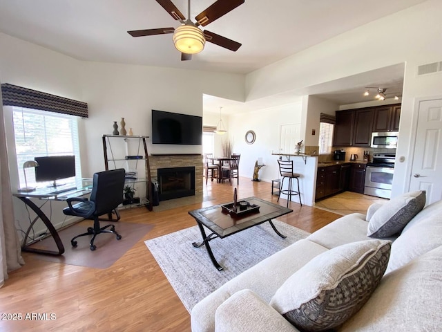 5335 E Shea Blvd Unit 2081, Scottsdale, AZ 85254 - living area featuring ceiling fan, light wood-style flooring, an office area, and a fireplace