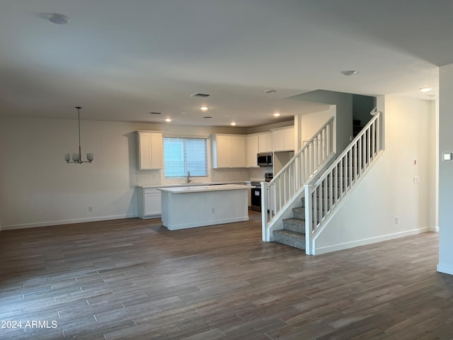 kitchen featuring white cabinetry, stainless steel appliances, dark wood-type flooring, and a kitchen island