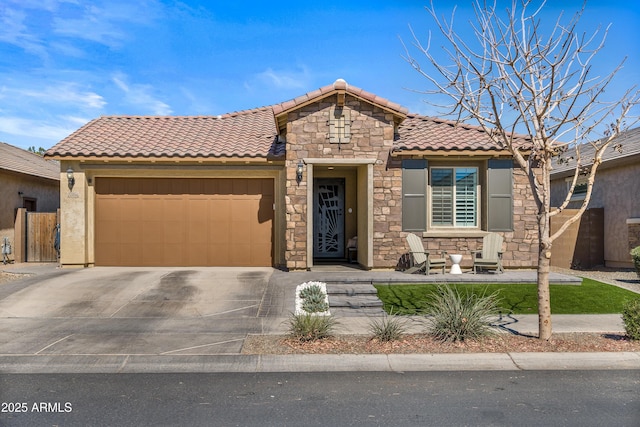 view of front of home featuring concrete driveway, stone siding, a tile roof, an attached garage, and stucco siding