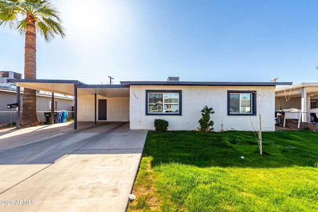 view of front of home with driveway, cooling unit, a front lawn, a carport, and stucco siding