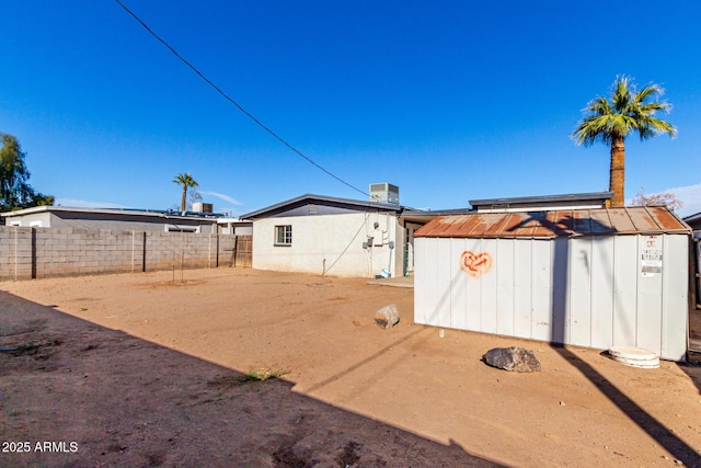 view of yard with a shed, an outdoor structure, fence, and central air condition unit