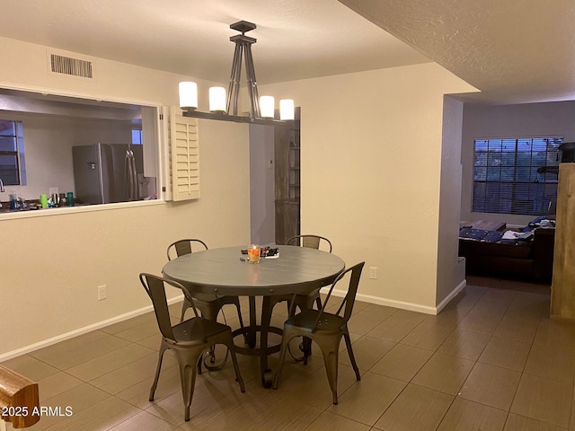 tiled dining area featuring an inviting chandelier