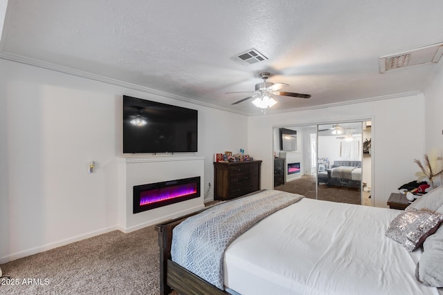 bedroom with ornamental molding, carpet flooring, a closet, and a textured ceiling