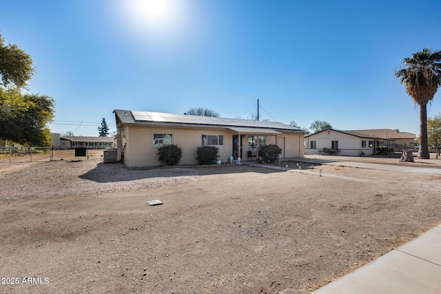 ranch-style home featuring a garage and solar panels