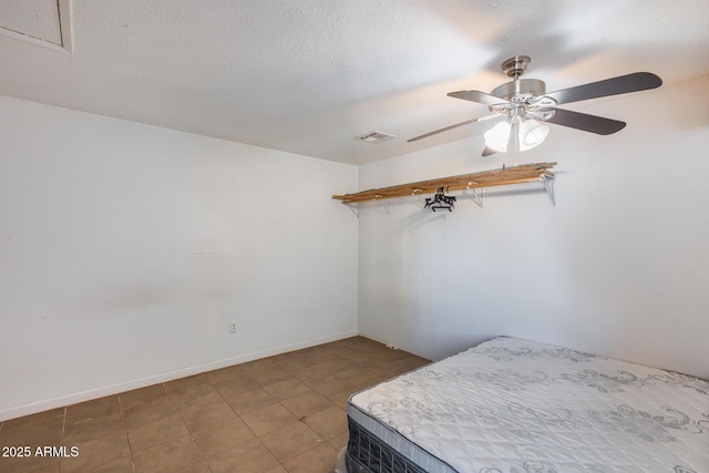 tiled bedroom featuring ceiling fan and a textured ceiling