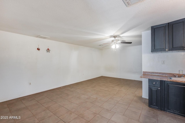 empty room featuring sink, a textured ceiling, and ceiling fan