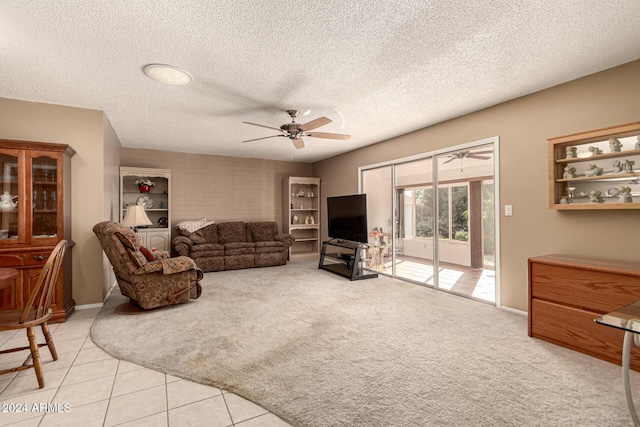 tiled living room with ceiling fan and a textured ceiling