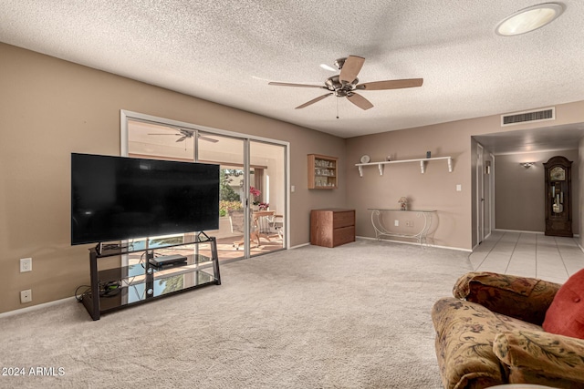 living room with a textured ceiling, ceiling fan, and light carpet