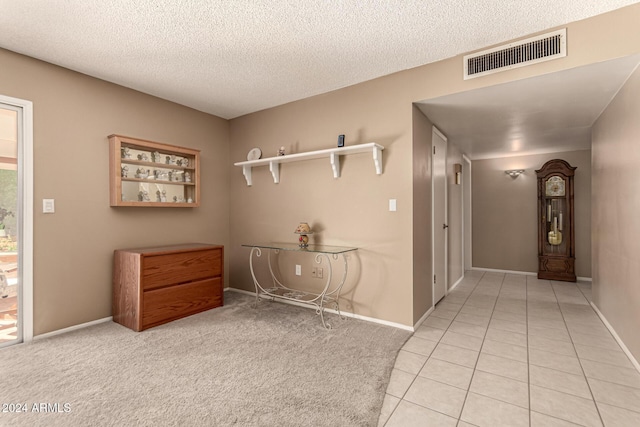 hallway featuring light tile patterned floors and a textured ceiling