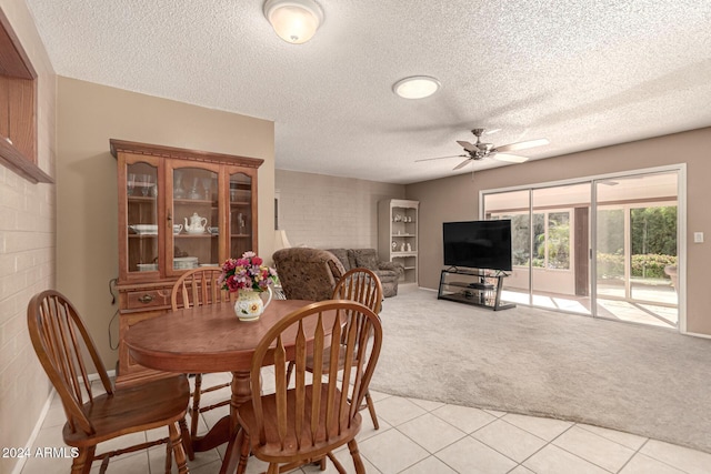 carpeted dining area with ceiling fan and a textured ceiling