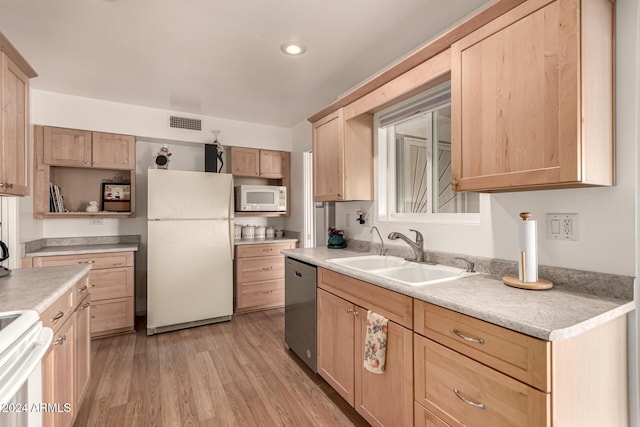 kitchen with light brown cabinetry, sink, white appliances, and light wood-type flooring