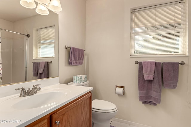 bathroom featuring toilet, plenty of natural light, vanity, and walk in shower